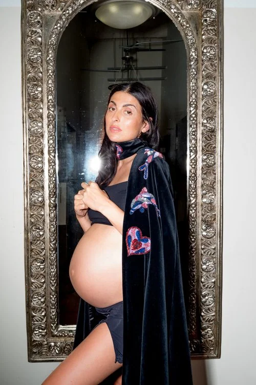 Flaunt portrait of Anna Lunoe with loose dark hair, a patterned robe and a rounded mirror.