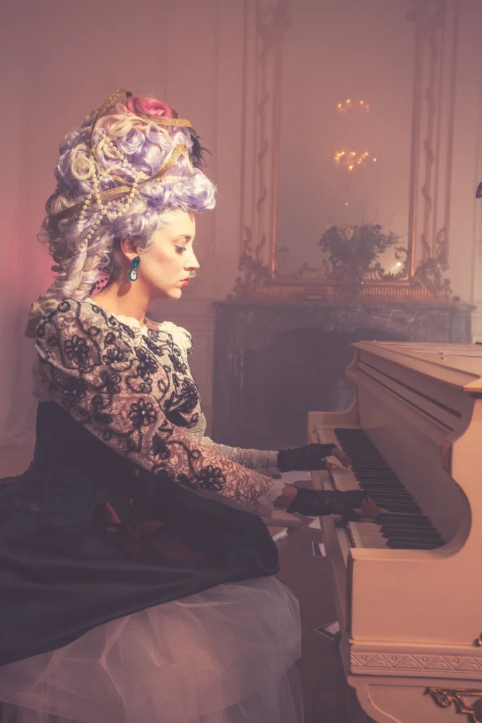 Charlotte Bash artwork with a sculptural gold updo, seated at a piano.